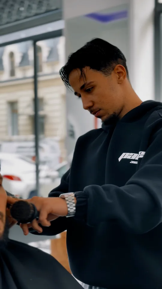 Louay au travail devant la vitre du salon, dans la vidéo de sa coupe